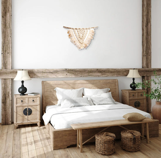 Tenture macramé Timucua suspenue à la tête d'un lit d'une chambre chaleureuse.